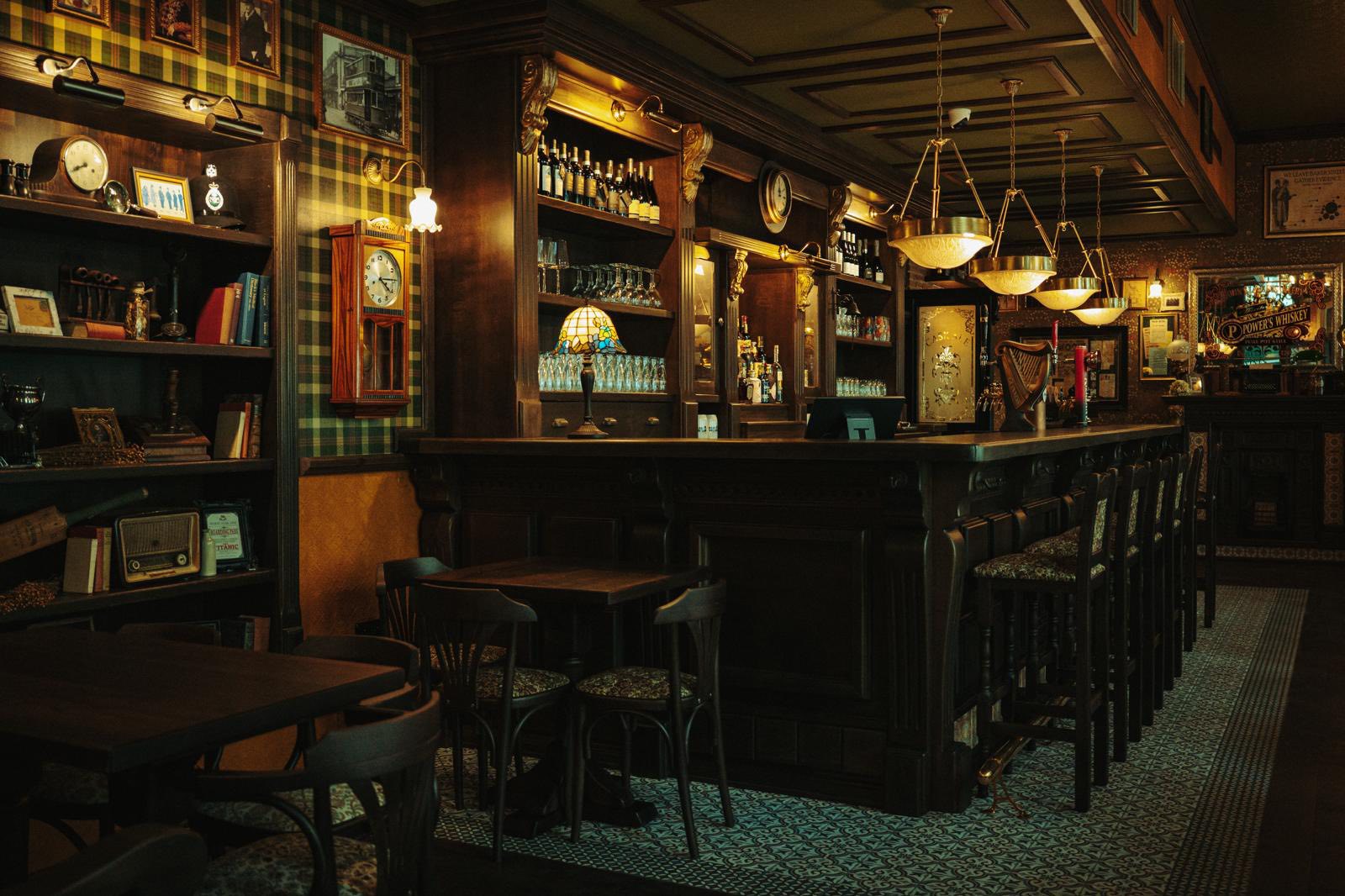 Dear Watson interior corner with dark wood furniture and warm pub lighting.